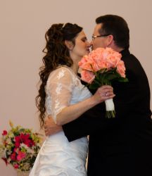 A romantic Christian couple lovingly kiss at their wedding