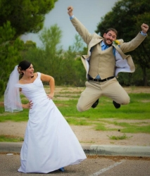A groom with an incredible vertical leaps for sheer joy next to his overcome wife