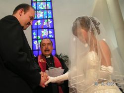 Woman in veil holds holds her husband's hands at their wedding ceremony