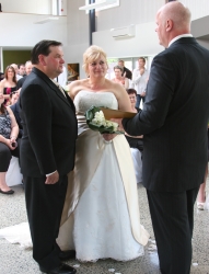 A groom stands next to his bride as the pastor reads a blessing over them