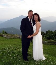 Gorgeous hills in the background as a newly wedded Christian couple smile and pose together