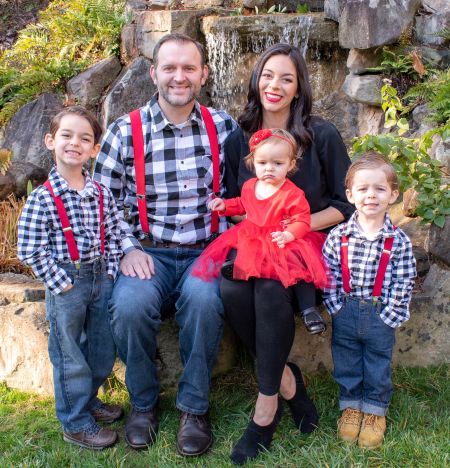 Very happy and proud Christian family with girls in dresses and boys in matching checkered shirts
