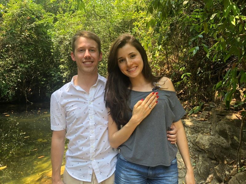 Newly engaged Christian woman shows off her ring near a stream