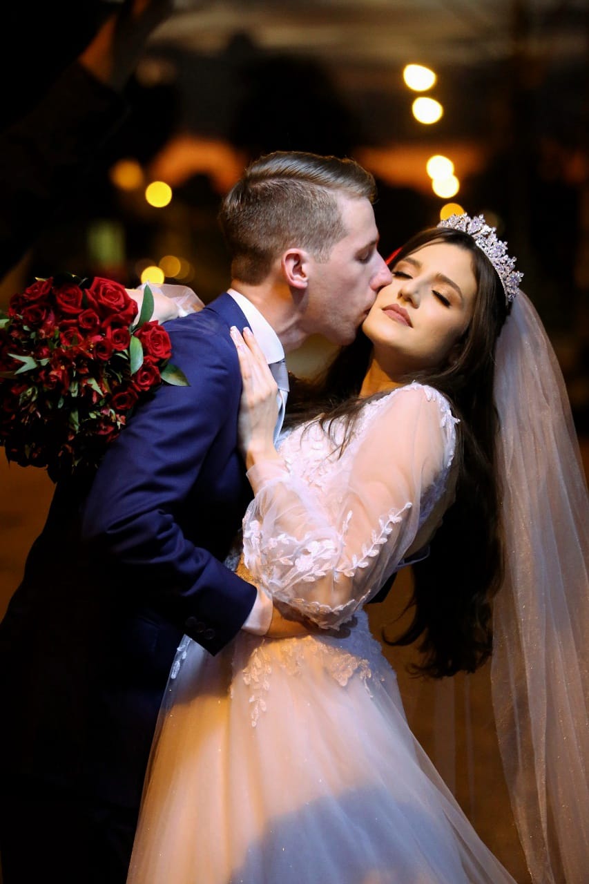 A Christian groom kisses his beautiful new bride