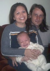 Christian couple try to soothe crying baby while posing together and smiling