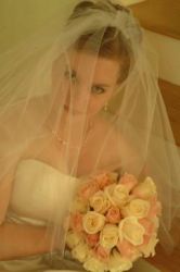A pretty bride in veil holds her flowers