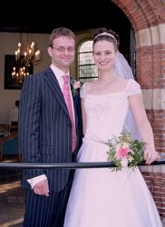 Overjoyed American Christian woman smiles on her wedding day standing next to her Dutch Christian husband
