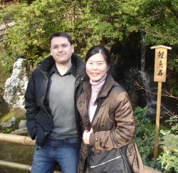 Canadian man meets a Japanese Christian woman. They both stand on a bridge on a cool but sunny day