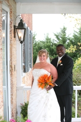 A very happy couple pose together on porch and smile