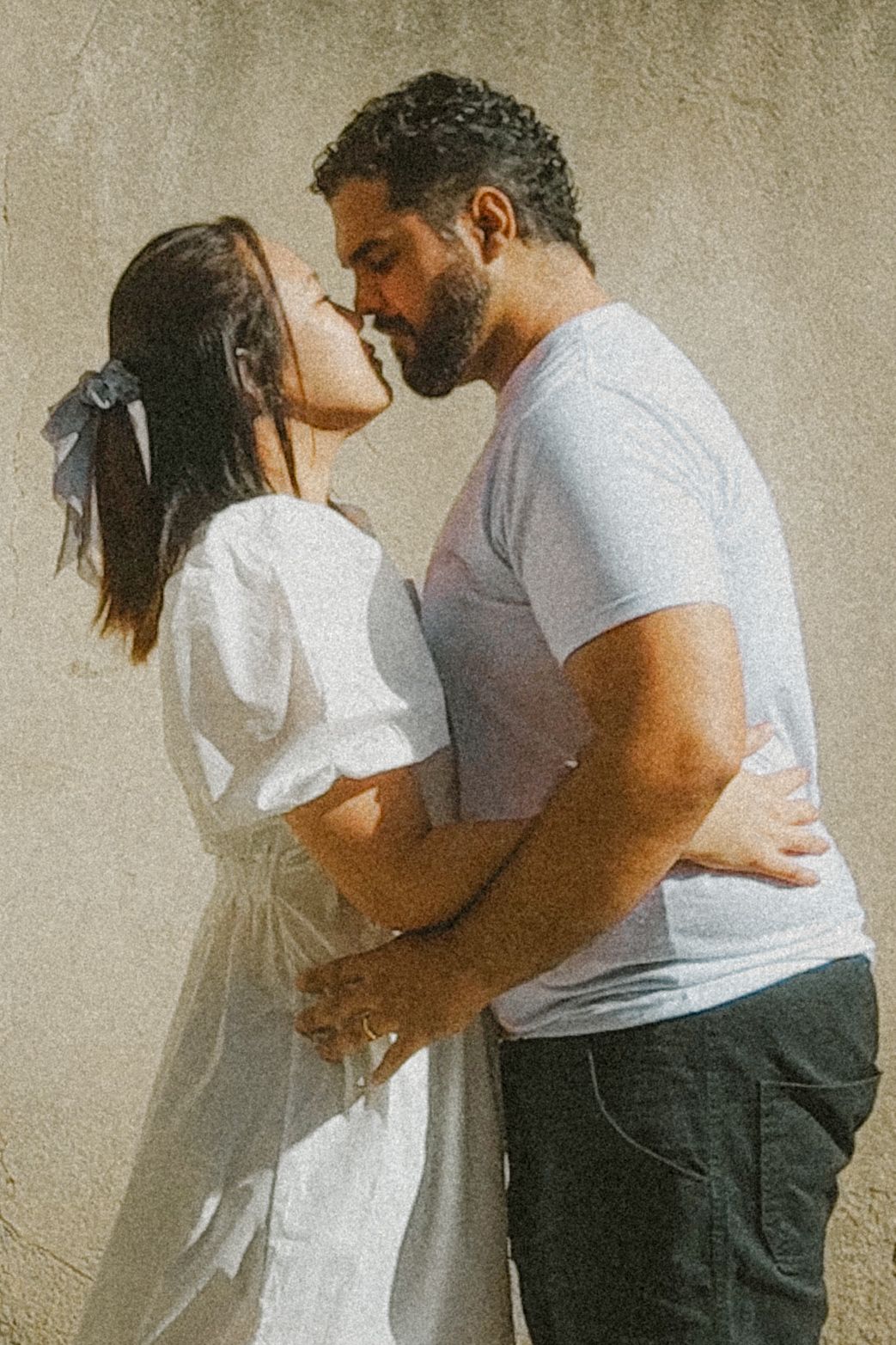 A married Christian couple nuzzle nose to nose in a romantic pose outdoors