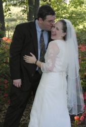 A man sneaks a kiss as his bride laughs joyfully