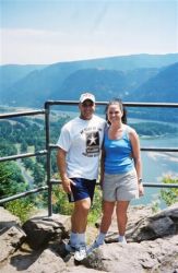A Christian couple go on a hiking date and pose together at a mountain lookout