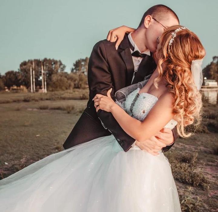 A newly married Christian man gives his new bride a passionate kiss outdoors shortly after they married