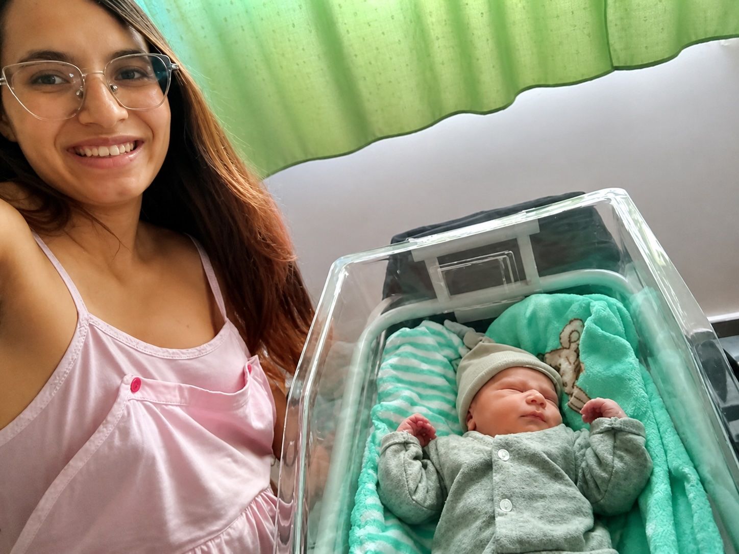 A new mother takes a selfie as her precious baby naps