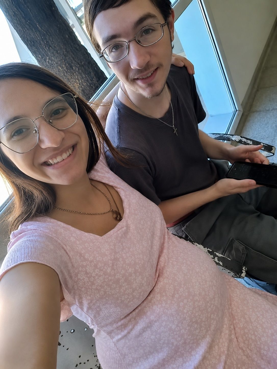 New parents smile while sitting together at the hospital
