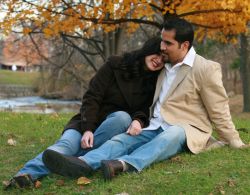 Touching photo of a woman lying her head on her man's shoulder in a park in Autumn