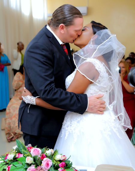 Interracial Christian couple kiss after marrying