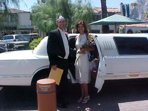 Christian couple recently married laugh as they step into limousine