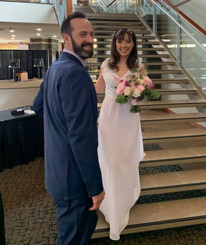 A Christian man smiles as his beautiful bride walks down the stairs