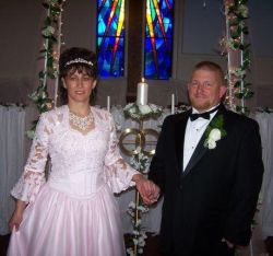 A Christian woman in a beautiful pink wedding dress holds hands with her handsome new husband