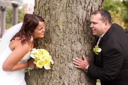 a joyful Christian couple play tag around a tree