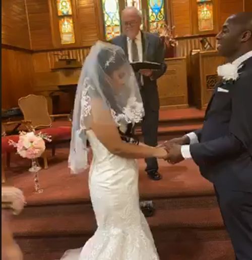 Groom says his wedding vows to Colombian bride who is veiled
