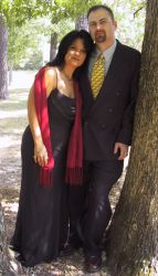 A Christian couple pose together against a tree and look very pleased