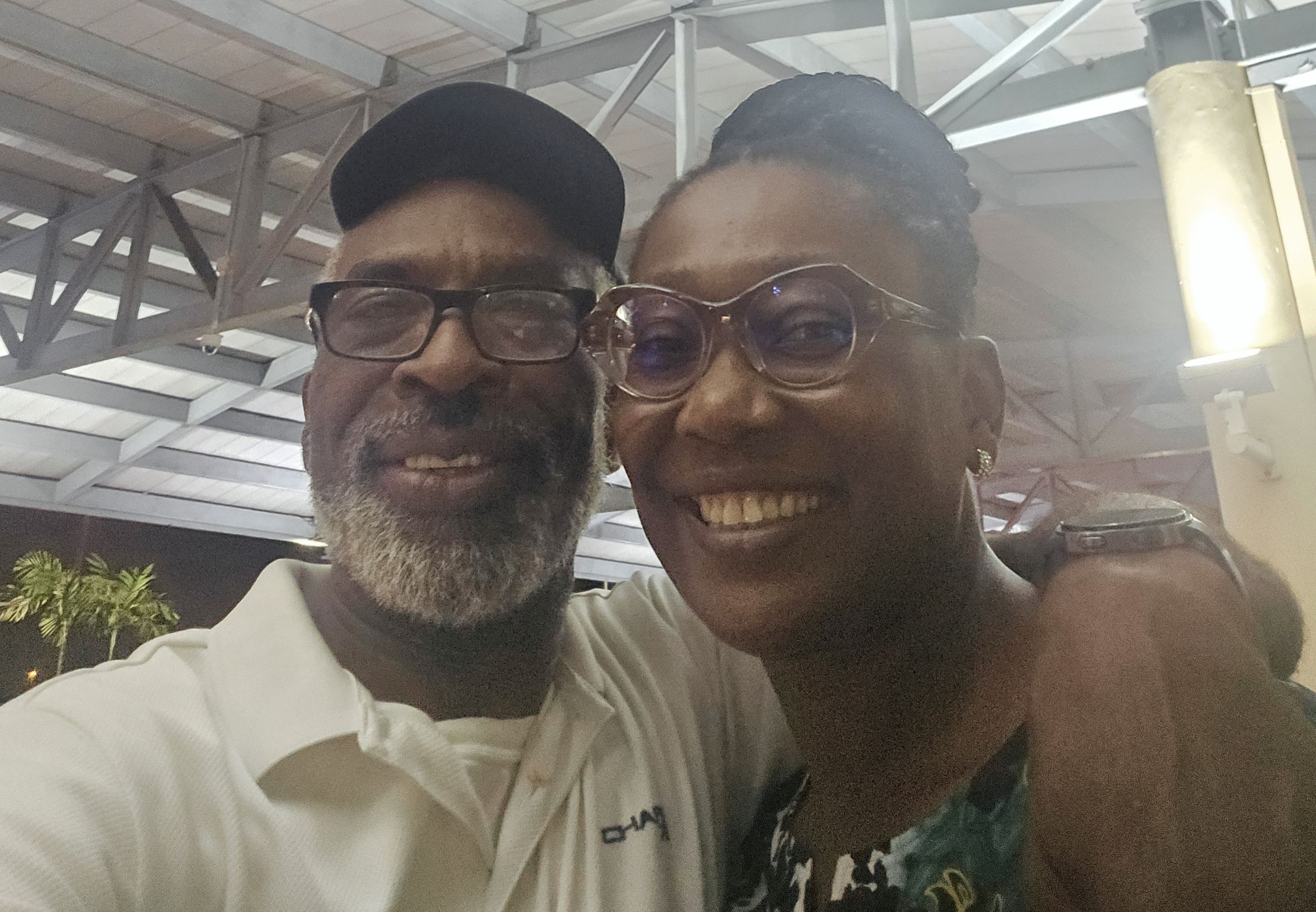A very happy woman beams with joy as her husband wraps his arm around her