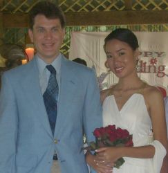 A pretty woman from the Philippines stands arm in arm with her new Hawaiian husband