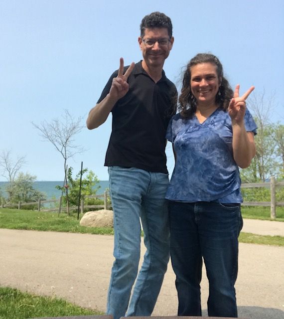Christian singles show the peace sign while posing together near Lake Ontario