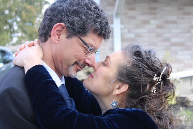 A couple nuzzle noses together outside