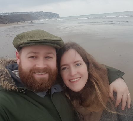 Coastal shot outdoors for bearded man and his beautiful wife