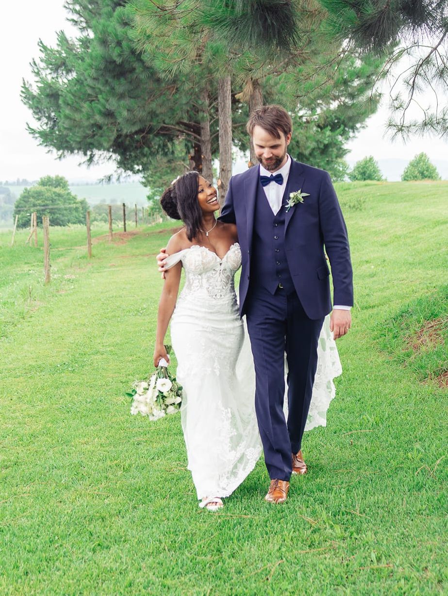Newly married Christian couple walk together on the grass