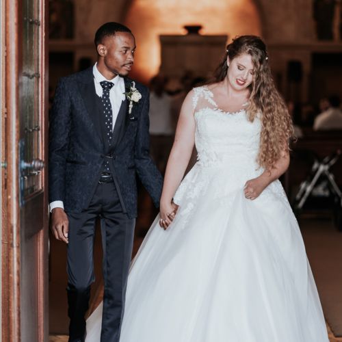 Beautiful Christian couple walk down the aisle with husband gazing at his wife