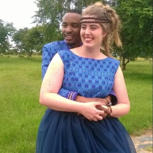 Traditional wedding for African Christian who holds his White wife in blue dress as they both smile