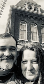 Christian couple take selfie in front of house in the city