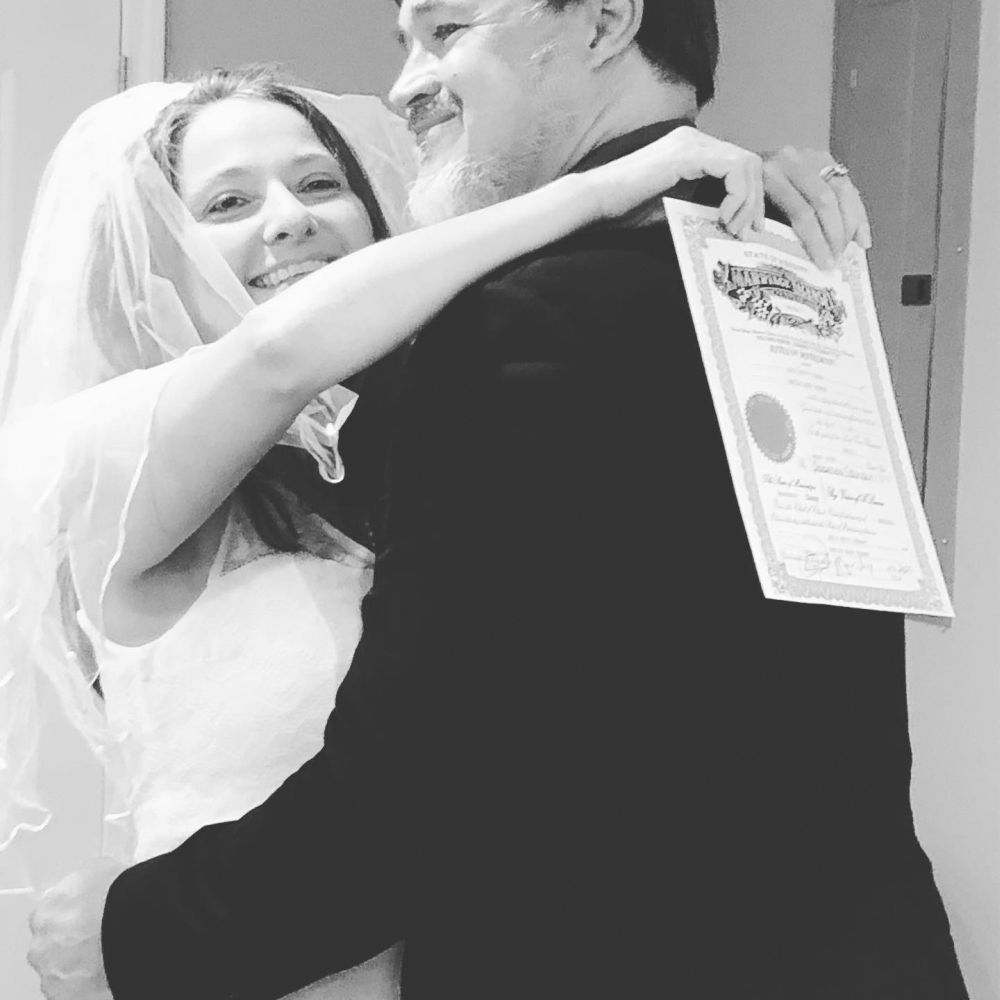 Christian bride shows proof of marriage as she hugs husband