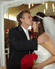 A former single Christian kisses his new wife's head as she smiles