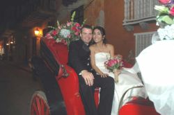 A carriage ride for the bride and groom who sit close together and smile
