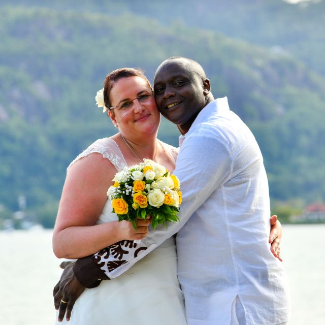 Beautiful interracial Christian couple hugging after marring in Seychelles