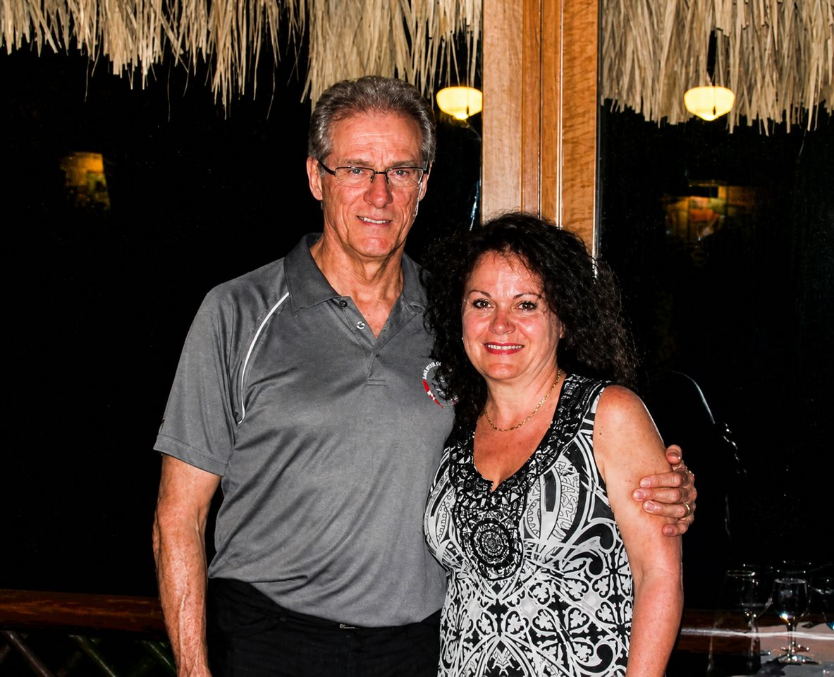Older Christian single standing with his arm around a smiling woman