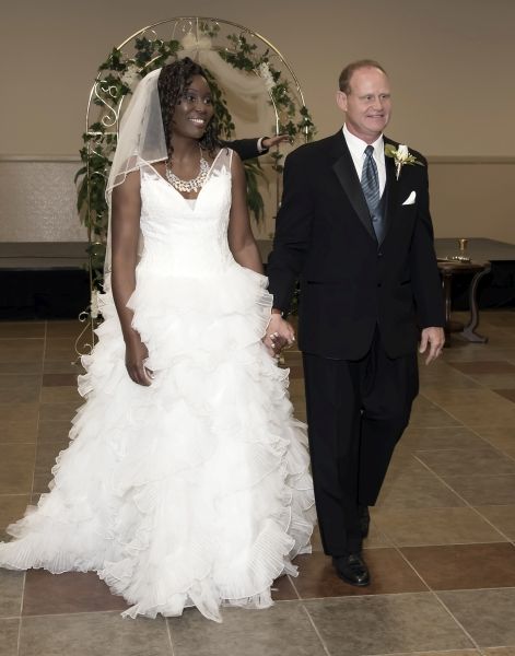 Newly married Christian couple walk into reception hall hand in hand
