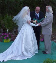 Senior Christians marry while holding hands and facing each other with the pastor giving his blessing