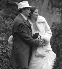Fashionable wedding for a man in hat and his beautiful wife in furs