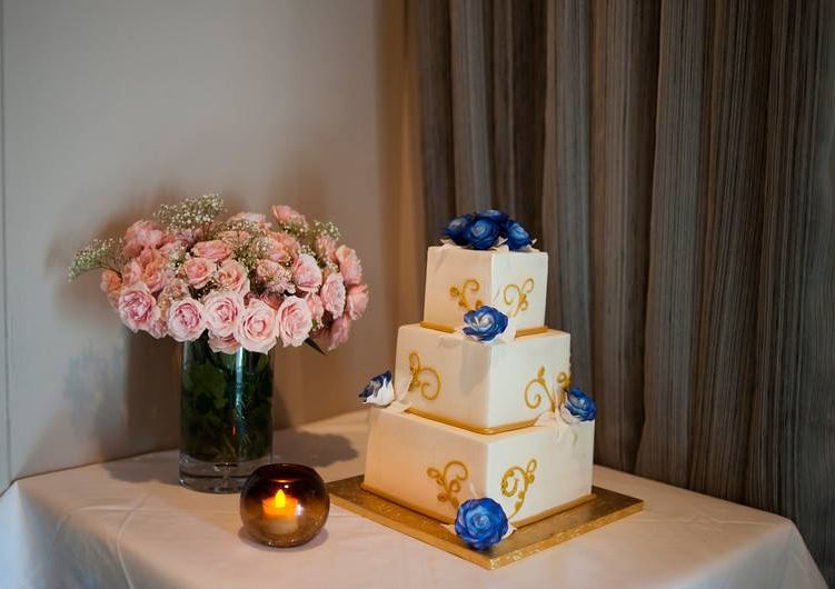 3 level wedding cake on table with pink roses