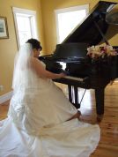 Bride plays piano in her wedding dress