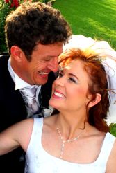 A couple laugh for joy outdoors after marrying