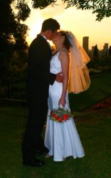 A couple kiss while silhouetted in the setting sun